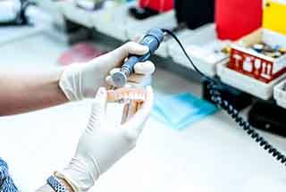 a lab technician polishing a denture