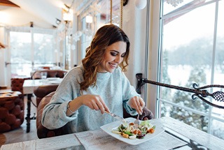 Woman smiling while eating lunch at restaurant