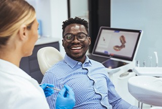 Man smiling while talking to dentist