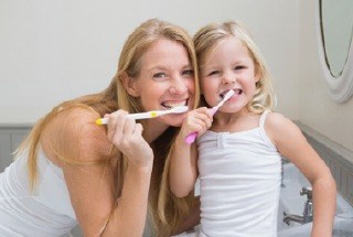 Mother and child brushing their teeth