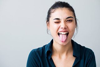 Young woman winking and sticking her tongue out